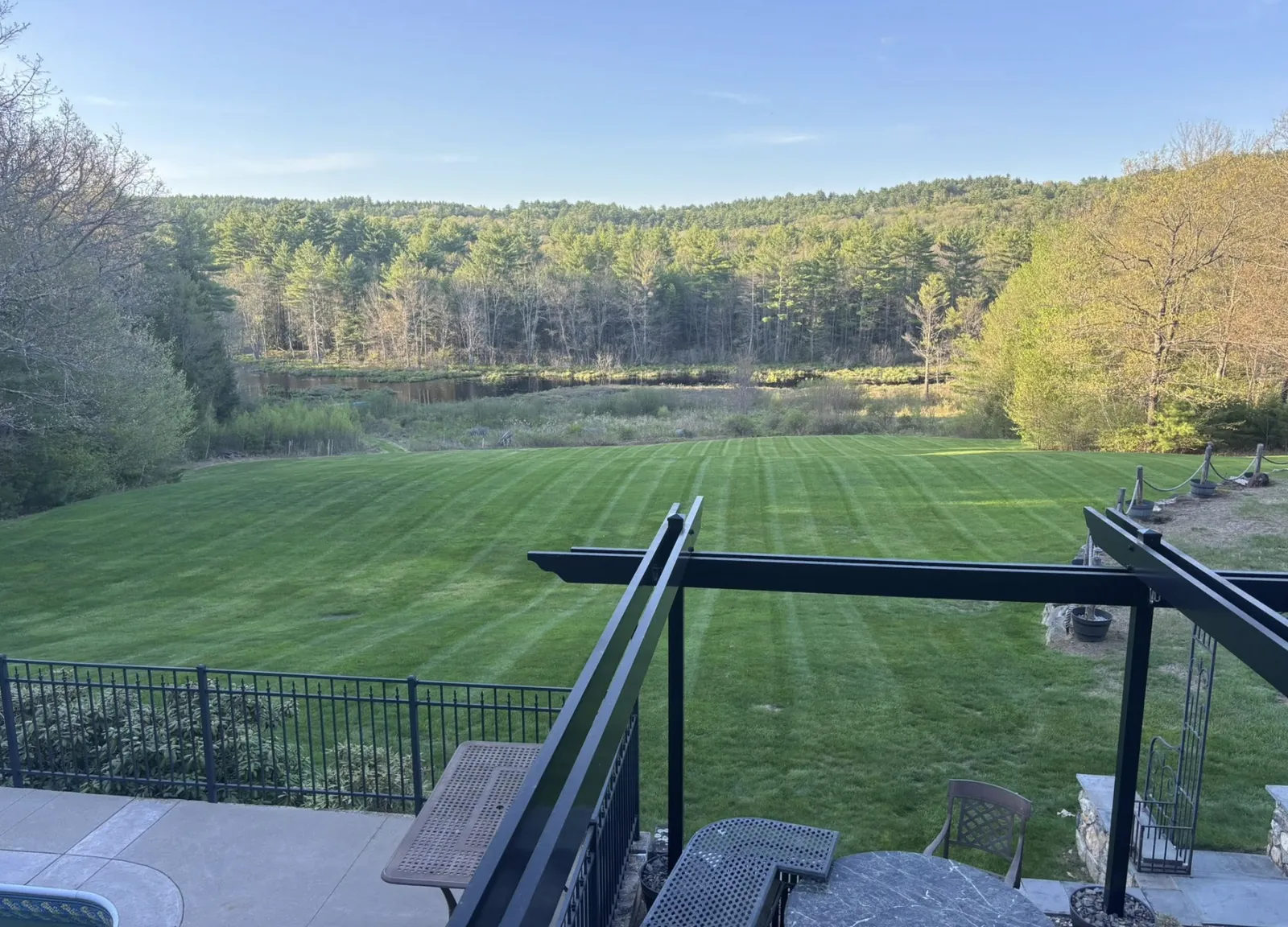 Freshly striped large lawn overlooking a New Hampshire pond and woodland
